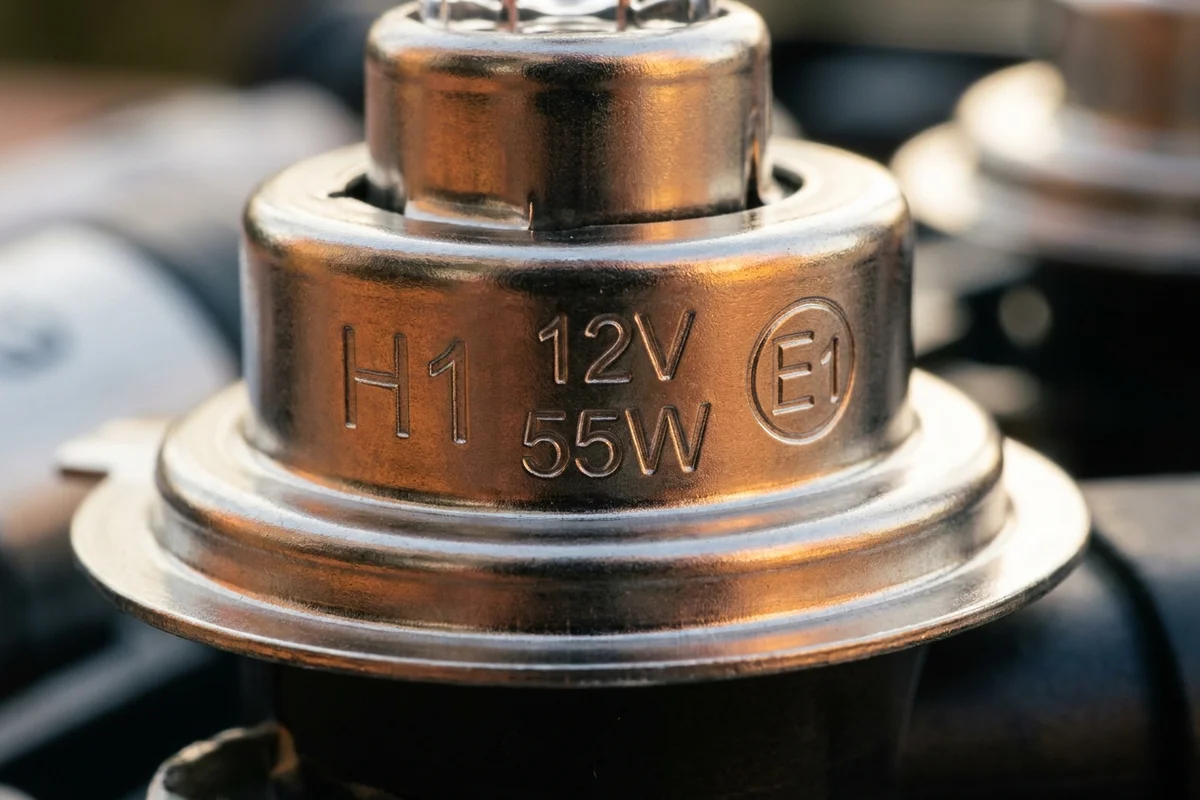 Oznaczenia H1, 12 V, 55 W oraz znak homologacji E na bańce i trzonku żarówki