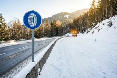 Dwie zimowe sytuacje drogowe: odcinek ze znakiem C-18 oraz zaśnieżona droga bez znaku nakazu