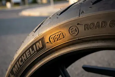 Fragment boku opony motocyklowej z czterocyfrowym kodem 3523 oraz znakiem homologacji E4