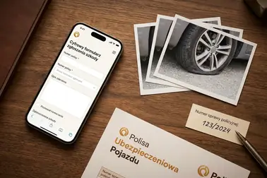 Telefon z formularzem zgłoszenia szkody obok zdjęć uszkodzonej opony, polisy i numeru sprawy