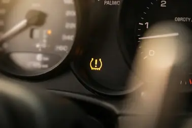 Żółta ikona opony z wykrzyknikiem oznaczająca ostrzeżenie TPMS