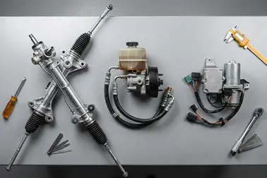 Elementy przekładni mechanicznej, pompy hydraulicznej i silnika elektrycznego EPS leżące na stole warsztatowym