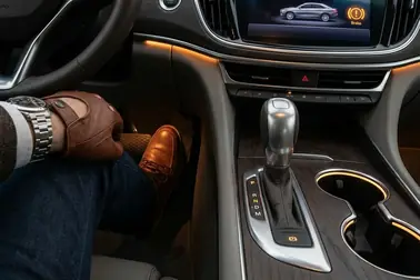 Kierowca trzymający wciśnięty pedał hamulca podczas zmiany pozycji wybieraka w automacie.