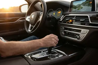 Kierowca wybierający niższe przełożenie automatycznej skrzyni przed stromym zjazdem