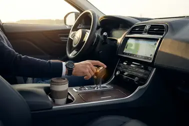 Kierowca zmieniający bieg w automatycznej skrzyni biegów podczas obserwacji objawów