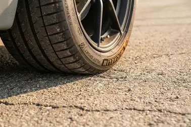 Koła samochodu skręcone na suchej nawierzchni podczas manewru wykonywanego na postoju
