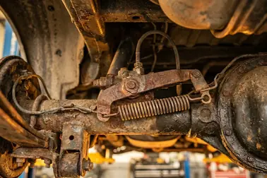 Mechaniczny korektor siły hamowania połączony dźwignią z tylną osią samochodu