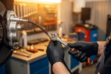 Mechanik dokręcający nowy elastyczny przewód hamulcowy specjalnym kluczem