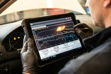 Mechanik sprawdzający parametry pracy silnika i ESP na tablecie diagnostycznym