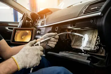Mechanik uzyskujący dostęp do parownika klimatyzacji podczas dokładnego czyszczenia
