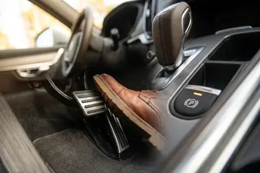 Pedał hamulca, dźwignia zmiany biegów i przycisk hamulca postojowego w samochodzie