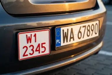 Polska tablica tymczasowa z czerwonymi znakami obok zwykłej białej tablicy