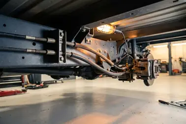 Przebieg linki hamulca ręcznego od dźwigni do mechanizmów przy tylnych kołach