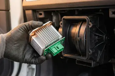 Rezystor lub elektroniczny regulator dmuchawy obok obudowy nawiewu