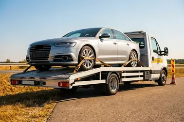 Samochód bez przedniej tablicy transportowany na lawecie