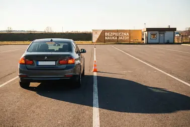 Samochód wykonujący ćwiczenie hamowania przed wyznaczonym punktem na zamkniętym placu