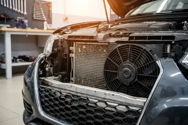 Skraplacz klimatyzacji i wentylator widoczne za przednią częścią samochodu