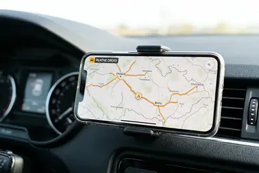 Smartfon z wyświetloną mapą czeskich płatnych dróg zamontowany na desce rozdzielczej