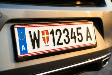 Standardowa austriacka tablica rejestracyjna z eurobandem A, czerwonym obramowaniem i herbem