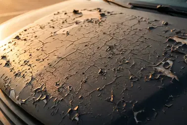 Stara folia na karoserii z pęknięciami i odrywającymi się drobnymi fragmentami