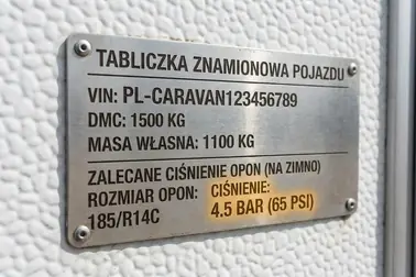 Tabliczka znamionowa i instrukcja przyczepy kempingowej używane do sprawdzenia zalecanego ciśnienia opon
