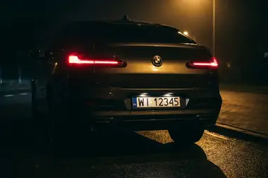 Tył samochodu z widocznymi światłami pozycyjnymi i oświetleniem tablicy rejestracyjnej