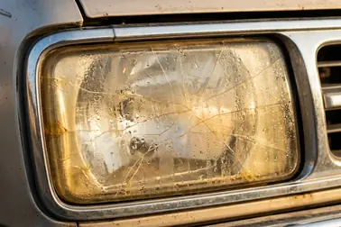 Zmatowiony i pęknięty klosz reflektora wymagający oceny przed nałożeniem folii