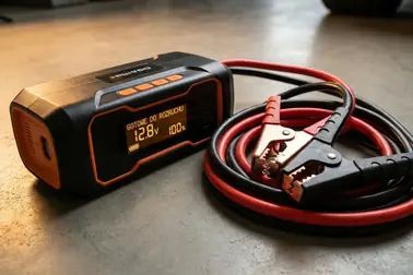 Booster z zaciskami oraz klasyczne kable rozruchowe przygotowane do porównania