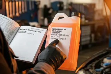 Etykieta płynu chłodniczego z oznaczeniem aprobaty porównywana z instrukcją samochodu