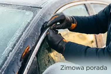 Kierowca delikatnie dociska obwód zamarzniętych drzwi samochodu, nie ciągnąc za klamkę