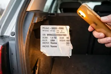Papierowa naklejka z kodami PR w bagażniku samochodu
